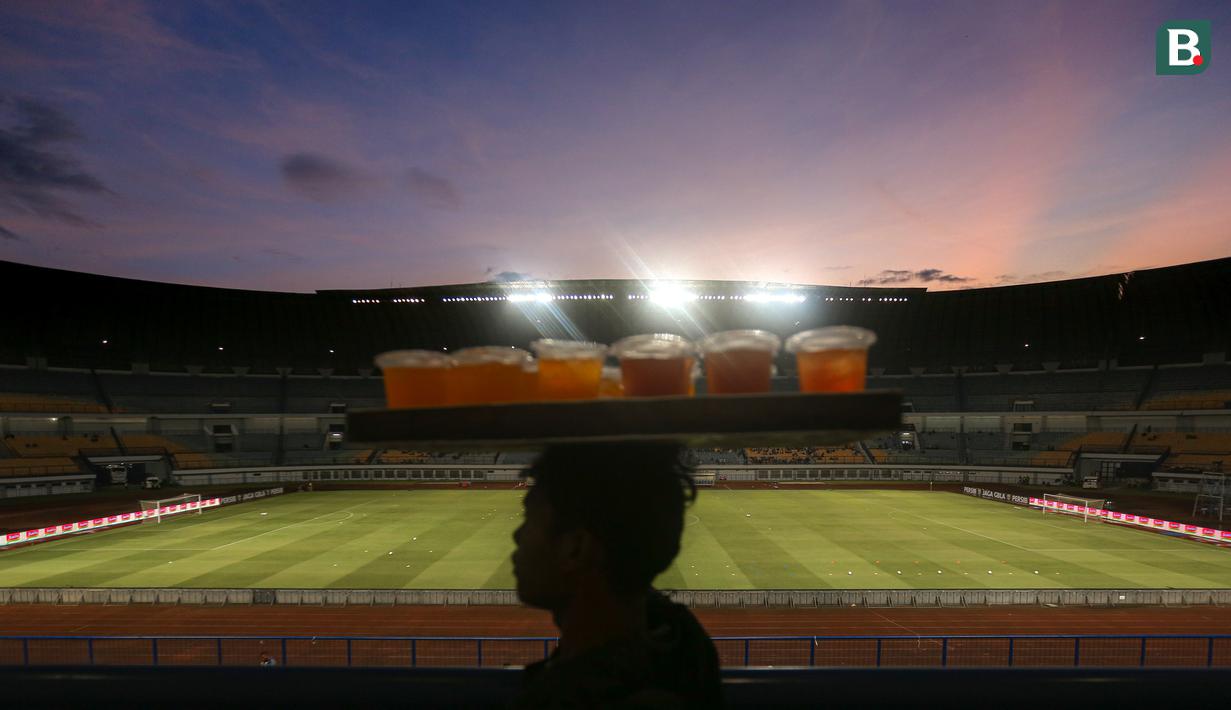 Seorang pedagang minuman melintas di tribun Stadion Utama Gelora Bandung Lautan Api (GBLA) menjelang laga pekan ketiga BRI Liga 1 2023/2024 antara Persib Bandung melawan Dewa United pada Jumat (14/07/2023). (Bola.com/Bagaskara Lazuardi)