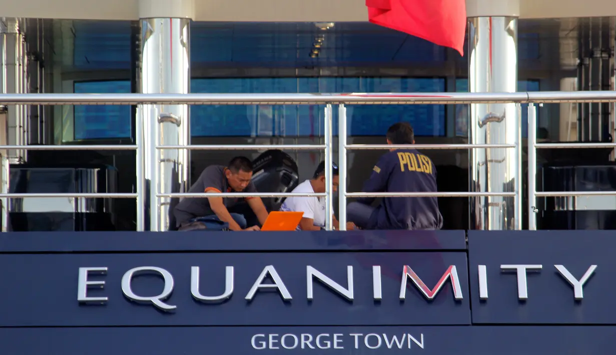 Petugas Polda Bali dengan penyidik FBI berada di atas kapal pesiar mewah (yacht) Equanimity di Teluk Benoa, Rabu (28/2). Kapal itu berwarna hitam kebiruan dan putih dengan bendera negara persemakmuran Inggris di bagian buritan. (AP/Ambros Boli Berani)
