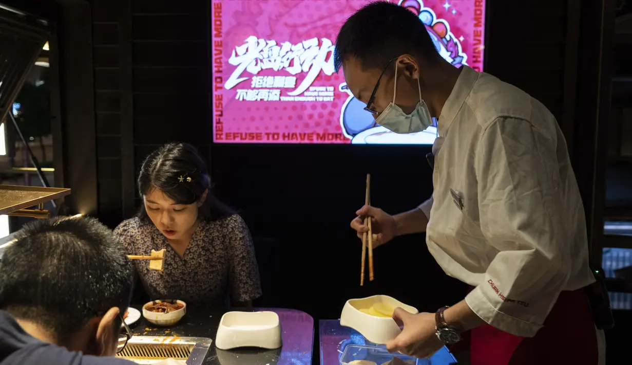 Seorang staf mengemas sisa bahan hot pot untuk para pelanggan restoran di Chengdu, Provinsi Sichuan, China, 7 September 2020. Banyak restoran hot pot di Chengdu menawarkan porsi makanan lebih kecil dan layanan takeaway dalam kampanye yang bertujuan mengurangi limbah makanan. (Xinhua/Li Mengxin)