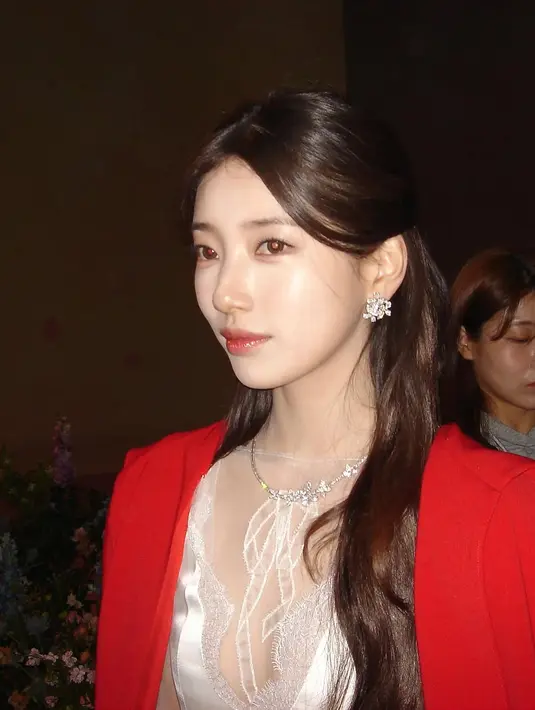 Makeup bernuansa soft peach dengan sentuhan shimmer di kelopak mata membuatnya terlihat segar dan bercahaya, sementara lipstik berwarna rosy pink memberikan kesan feminin yang lembut. [@skuukzky/@management_soop].