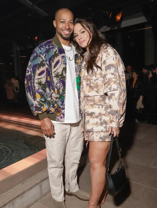 <p>Ashley Graham (kanan) dan Justin Ervin menghadiri koleksi siap pakai Isabel Marant Fall/Winter 2023-2024 yang dipresentasikan Paris, Prancis, 2 Maret 2023. Justin Ervin tampil stylish dengan celana cargo berwarna beige dan kaos putih, tambahan kardigan rajut warna-warni ke ansambelnya melengkapi penampilannya. (Vianney Le Caer/Invision/AP)</p>