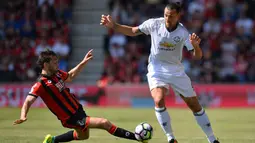 Penyerang Manchester United, Zlatan Ibrahimovic, berusaha melewati pemain Bournemouth, Harry Arter. Bagi Ibra ini merupakan kali pertama dirinya mencicipi kompetisi Liga Inggris. (AFP/Glyn Kirk)