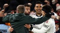 Ada kejadian menarik setelah gol ketiga MU yang dicetak oleh Bruno Fernandes. Seorang suporter lolos dari kawalan petugas dan melakukan selebrasi bersama Bruno Fernandes, Casemiro, dan Lisandro Martinez. (AFP/Darren Staples)