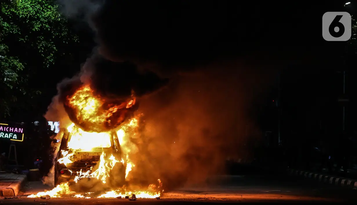 Sebuah mobil terbakar di Jalan Asia Afrika, Jakarta, Kamis (18/3/2021) dinihari. Kobaran api yang melahap mbil jenis minibus bernomor polisi B 1608 SGZ itu menjadi tontonan warga. (Liputan6.com/Johan Tallo)