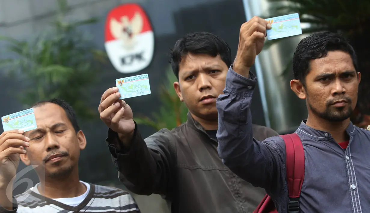 Sejumlah orang yang tergabung dalam Koalisi Masyarakat Sipil menunjukan KTP Elektronik saat melakukan aksi di depan Gedung KPK, Jakarta, Minggu (12/3). (Liputan6.com/Immanuel Antonius)