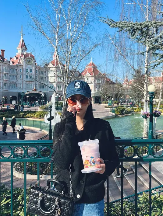 Tidak ketinggalan, Jisoo juga terlihat mengunjungi Disneyland kembali membawa D-Joy Bagnya dengan oversized cardigan berkancing berwarna hitam, celana jeans dan topi biru. Foto: Instagram.