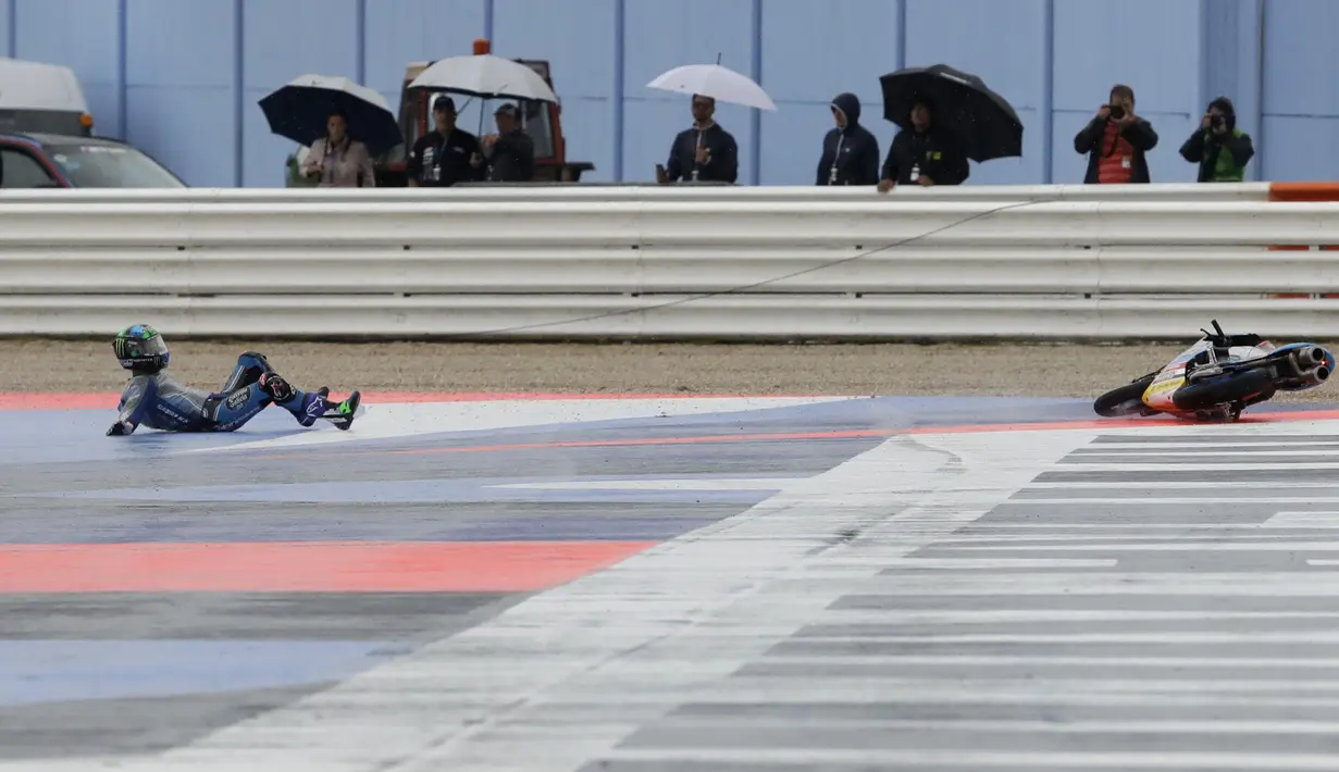 Pebalap Moto 3, Enea Bastianini dari Italy jatuh pada track basah balapan San Marino Motorcycle Grand Prix di Sirkuit Marco Simoncelli, San Marino (10/9/2017). (AP/Antonio Calanni)