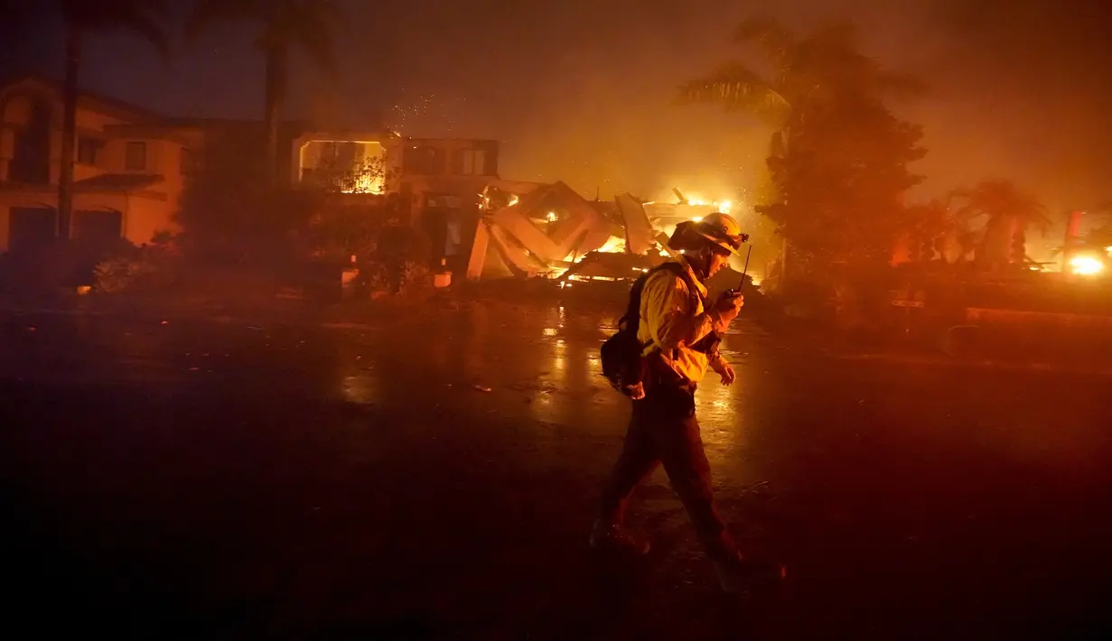 Seorang petugas pemadam kebakaran bekerja untuk memadamkan bangunan yang terbakar saat kebakaran hutan di Laguna Niguel, California, Amerika Serikat, 11 Mei 2022. (AP Photo/Marcio J. Sanchez)