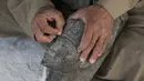 Seorang pemahat bekerja di sebuah bengkel kerajinan alabaster atau sejenis batu pualam di Desa Gurna, Luxor, Mesir, 17 Desember 2020. Desa Gurna terkenal sebagai penghasil kerajinan tangan dan suvenir bergaya Mesir kuno yang dibuat dari pahatan alabaster. (Xinhua/Ahmed Gomaa)