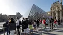 Museum Louvre Kembali Dibuka: Pengunjung mengantre di piramida Louvre, pintu masuk ke Museum Louvre pada hari pertama pembukaan di Paris (6/7/2020). Setelah berbulan-bulan ditutup akibat lockdown Covid-19, Museum Louvre  kembali dibuka pada 6 Juli 2020. (AFP/Francois Guillot)