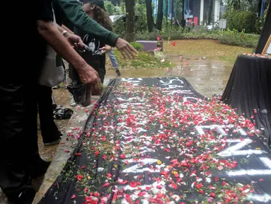 Aktivis menabur bunga pada foto Bernardus Realino Norma Wirawan dalam pada peringatan 21 Tahun Tragedi Semanggi I di halaman Universitas Atma Jaya, Jakarta, Rabu (13/11/2019). Mereka menuntut kepada Presiden mengusut tragedi yang hingga kini belum ada kejelasan hukumnya. (Liputan6.com/Faizal Fanani)