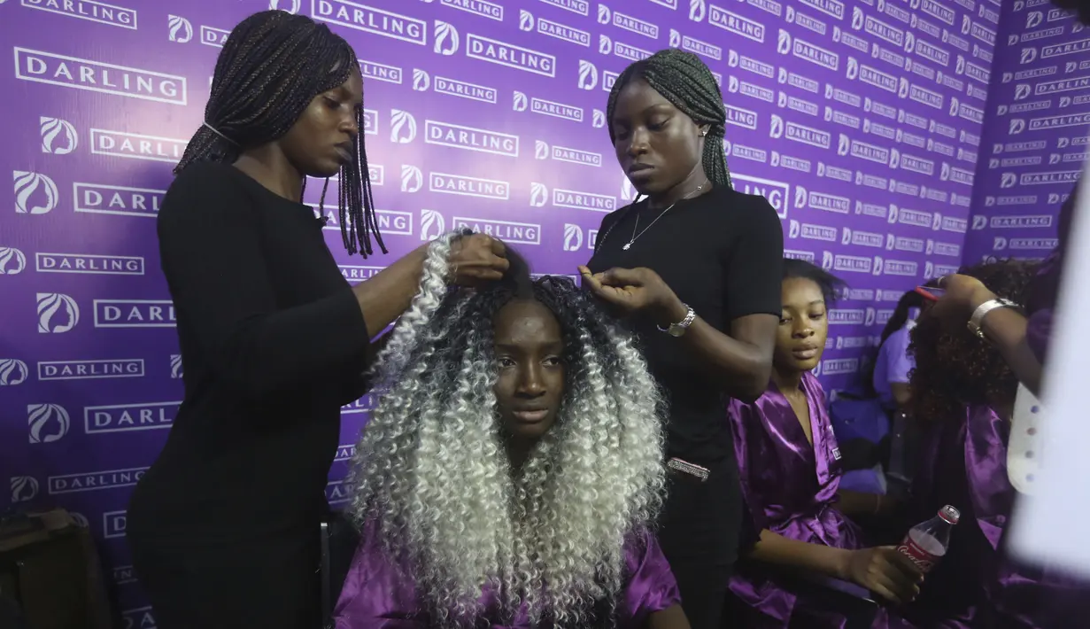 Seorang model ditata rambutnya di belakang panggung  Lagos Fashion Week di Lagos, Nigeria (25/10/2019). Lagos Fashion Week (LFWNG) adalah acara mode multi-hari tahunan yang didirikan pada 2011 oleh Omoyemi Akerele. (AP Photo/Sunday Alamba)