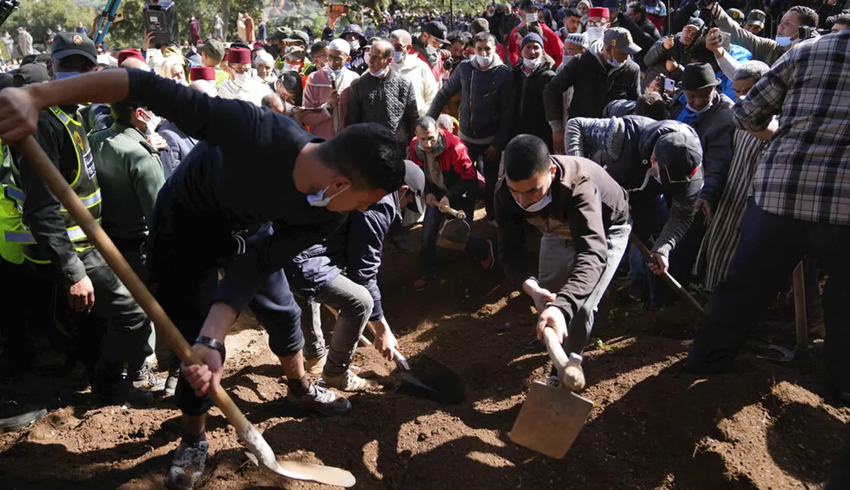 Pekerja menutupi makam yang digali untuk Rayan Oram (5) saat pemakamannya di Desa Ighran, Provinsi Chefchaouen, Maroko, 7 Februari 2022. Rayan Oram meninggal setelah terjebak selama lima hari dalam sumur kering sedalam 32 meter. (AP Photo/Mosa'ab Elshamy)