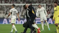 Momen David Alaba ditandu keluar lapangan akibat cedera. Pada laga ini Real Madrid mengalahkan Villarreal dengan skor 4-1 di ajang Liga Spanyol 2023/2024. (Thomas COEX / AFP)