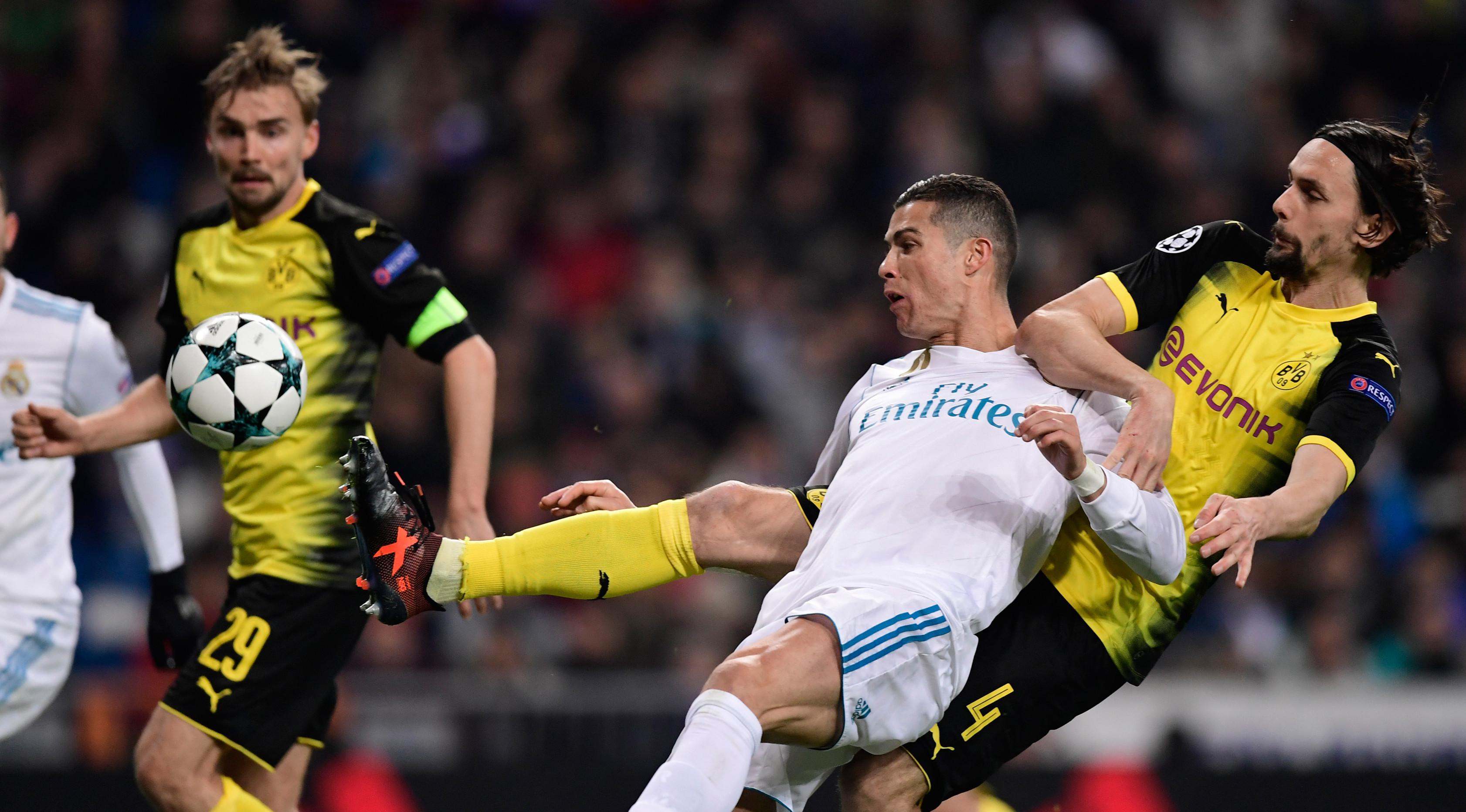 Bek Borussia Dortmund, Neven Subotic berebut bola dengan pemain Real Madrid Cristiano Ronaldo pada matchday terakhir Grup H Liga Champions di Stadion Santiago Bernabeu, Kamis (7/12). Real Madrid unggul 3-2 atas Borussia Dortmund. (JAVIER SORIANO/AFP)