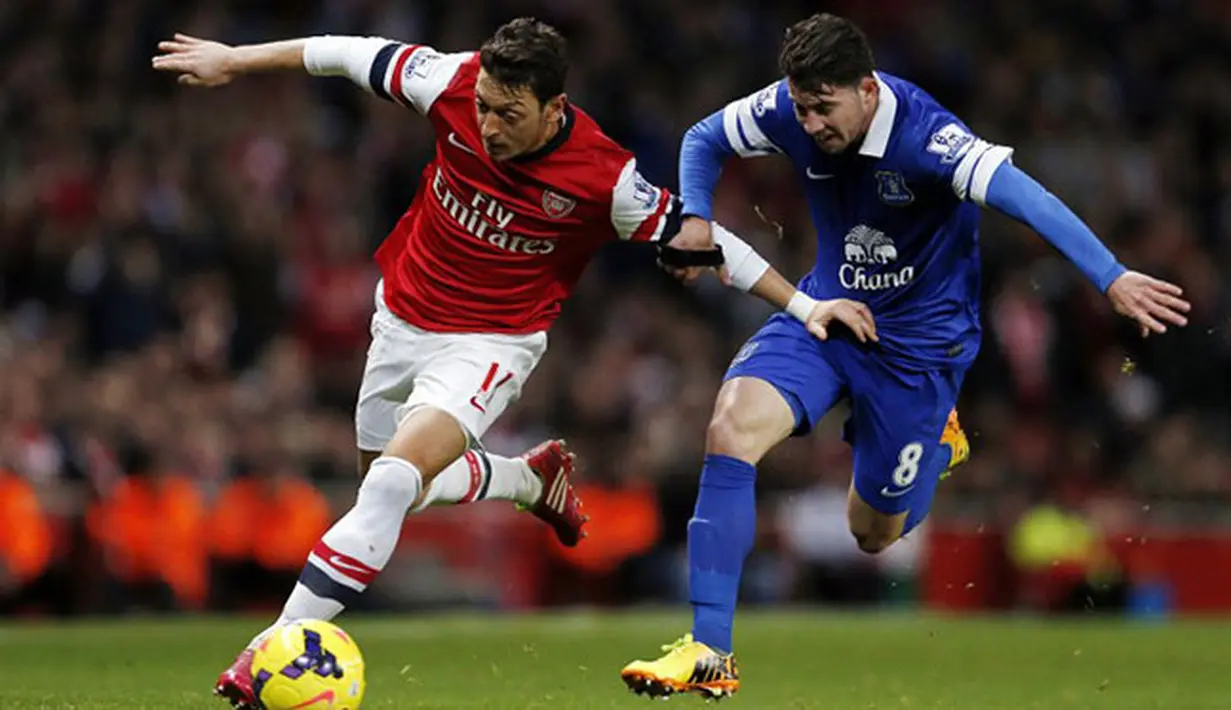 Duel Mesut Oezil dan Bryan Oviedo, Minggu 8 Desember 2013. (AFP/Adrian Dennis)