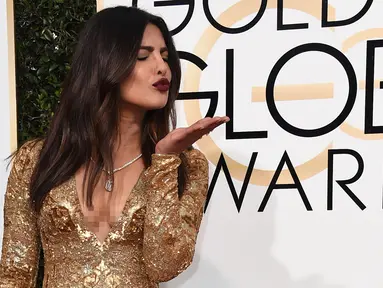 Bintang Bollywood Priyanka Chopra memeriahkan gelaran red carpet Golden Globe 2017 di California, Minggu (8/1). Priyanka tampil memukau mengenakan gaun panjang warna emas dari Ralph Lauren yang berbelahan dada rendah. (Jordan Strauss/Invision/AP)