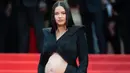 <p>Adriana Lima memperlihatkan baby bumpnya di red carpet. Ia tampil luar biasa dalam balutan cut-out dress hitam dari Balmain. Foto: Vogue.</p>