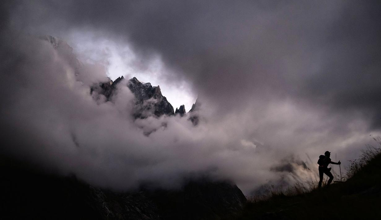 Siluet seorang atlet saat pagi hari di 'Arete du Mont Favre' saat ajang The Ultra Trail du Mont Blanc (UTMB) yang menempuh jarak 173km dari Prancis, Italia, hingga Swiss pada 2 September 2023. (AFP/Jeff Pachoud)