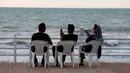 Warga Iran bermain ponsel saat menikmati pantai di kota Laut Kaspia, Izadshahr, di provinsi Mazandaran utara (8/7/2019). Laut Kaspia terletak di antara Eropa dan Asia, di sebelah barat dan barat-daya pegunungan Ural. (AFP Photo/Atta Kenare)