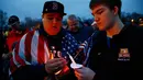 Dua warga Dorchester menyalakan lilin untuk peringatan satu tahun pemboman Boston Marathon yang menewaskan tiga orang dan melukai sekitar 264 orang lain (AFP/Jared Wickerham)