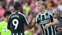 Striker Manchester United, Rasmus Hojlund (kanan) bersiap memasuki lapangan menggantikan rekannya, Anthony Martial saat menghadapi Arsenal pada laga pekan ke-4 Liga Inggris 2023/2024 di Emirates Stadium, London (3/9/2023). (AFP/Glyn Kirk)