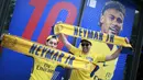 Fans berpose di depan gambar pemain baru Paris Saint Germain, Neymar Jr, di toko merchandise di Paris, Jumat (4/8/2017). Setelah resmi bergabung dengan Paris Saint Germain, jersey Neymar Jr langsung diburu suporter klub Ibu kota. (AFP/Benjamin Cremel)