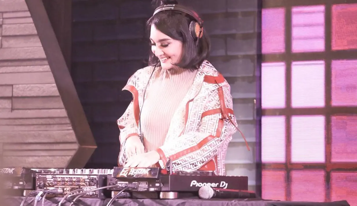 Tak jarang DJ Kiam, sapaan Kiki Amalia ketika nge-DJ, menggunakan outifit kaos dan juga jaket. Tak lupa senyumnya yang manis membuatnya semakin cantik. (Liputan6.com/IG/@kikiamaliaworld)