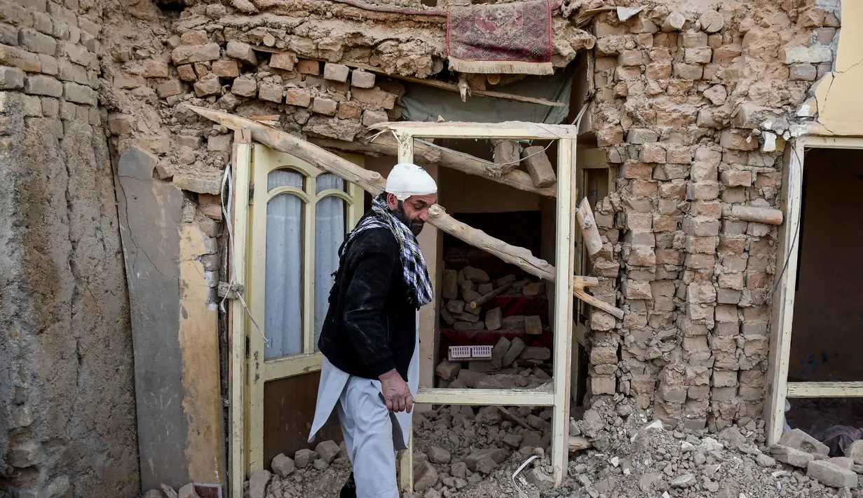 Seorang penyintas gempa bumi Afghanistan berjalan melewati reruntuhan rumah yang rusak di sebuah desa di Tashqurghan, distrik Khulm, provinsi Samangan, pada Senin 3 November 2025. Jumlah korban diperkirakan akan terus bertambah seiring berlanjutnya upaya penyelamatan. (Atif Aryan/AFP)