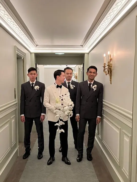 Sedangkan, Kevin mengenakan jas putih lengkap drngan dasi kupu-kupu dari Wong Hang Tailor. Atasan pun dipadukan celana dan sepatu hitam. Credit @lxemoments