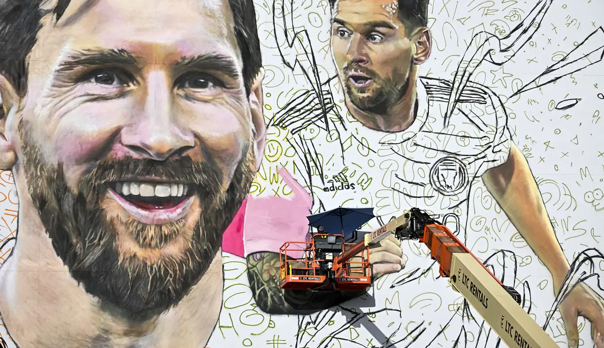 <p>Seniman Argentina, Maximiliano Bagnasco sedang mengerjakan mural besar bergambar Lionel Messi di Wynwood, Miami, 10 Juli 2023. La Pulga akan melakukan debutnya di Inter Miami pada 21 Juli di Piala Liga. (AFP/Chandan Khanna)</p>