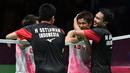Pasangan Indonesia, Hendra Setiawan/Mohammad Ahsan memeluk wakil Jepang, Takuro Hoki/Yugo Kobayashi, usai menjuarai Kejuaraan Dunia Bulutangkis 2019 Minggu (25/8). Indonesia menang 25-23, 9-21, 21-15. (AFP/Fabrice Coffrini)