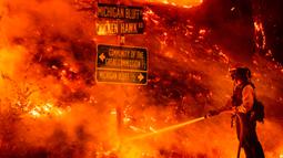 Seorang petugas pemadam kebakaran memadamkan Mosquito Fire yang menyala dekat komunitas Michigan Bluff di Placer County, California, Amerika Serikat, 7 September 2022. (AP Photo/Noah Berger)