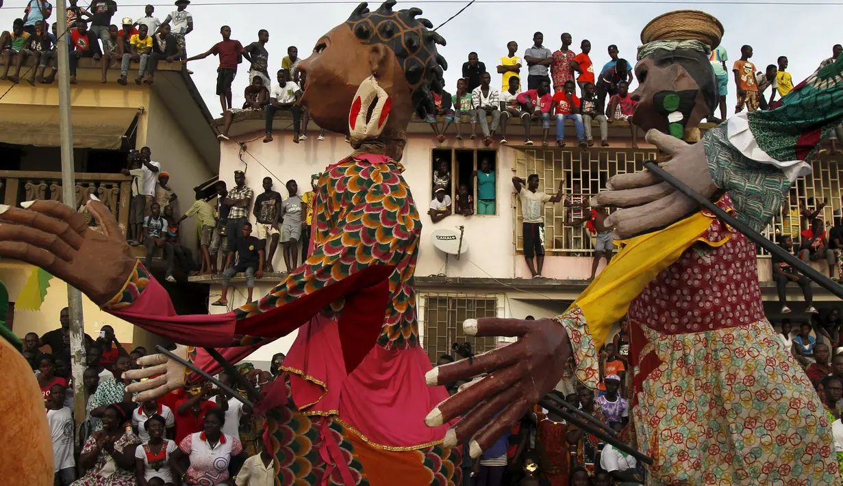 Boneka - boneka berukuran besar turun ke jalan untuk mengikuti parade Popo (topeng) dalam karnaval Bonoua , di timur Abidjan, Pantai Gading, (9/4). (REUTERS / Luc Gnago)