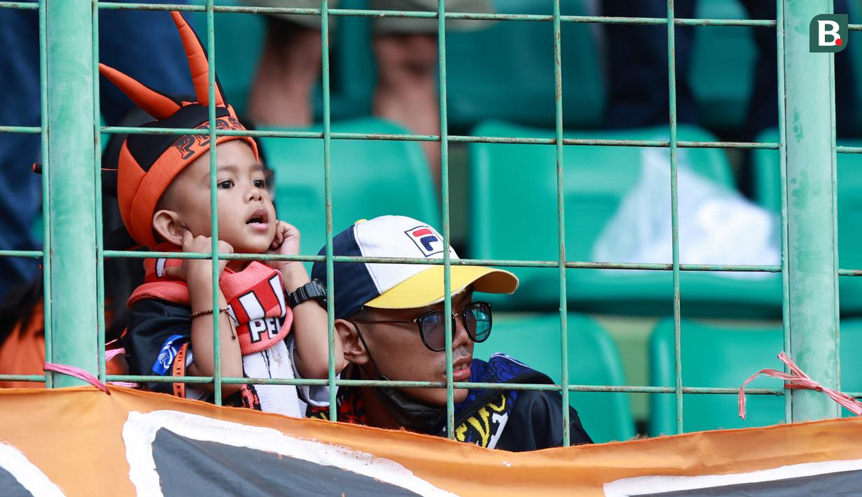Suporter Cilik saat menyaksikan pertandingan Persija Jakarta melawan Arema FC pada laga BRI Liga 1 di Stadion Patriot Candrabhaga, Bekasi, Minggu (12/2/2023). (Bola.com/M Iqbal Ichsan)