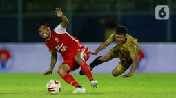 Pemain Persija Jakarta Sandi Sute (kiri) berebut bola dengan pemain Bhayangkara Solo FC TM Ichsan pada laga Piala Menpora 2021 di Stadion Kanjuruhan, Malang, Rabu (31/3/2021). Persija menang 2-1. (Bola.com/M Iqbal Ichsan)