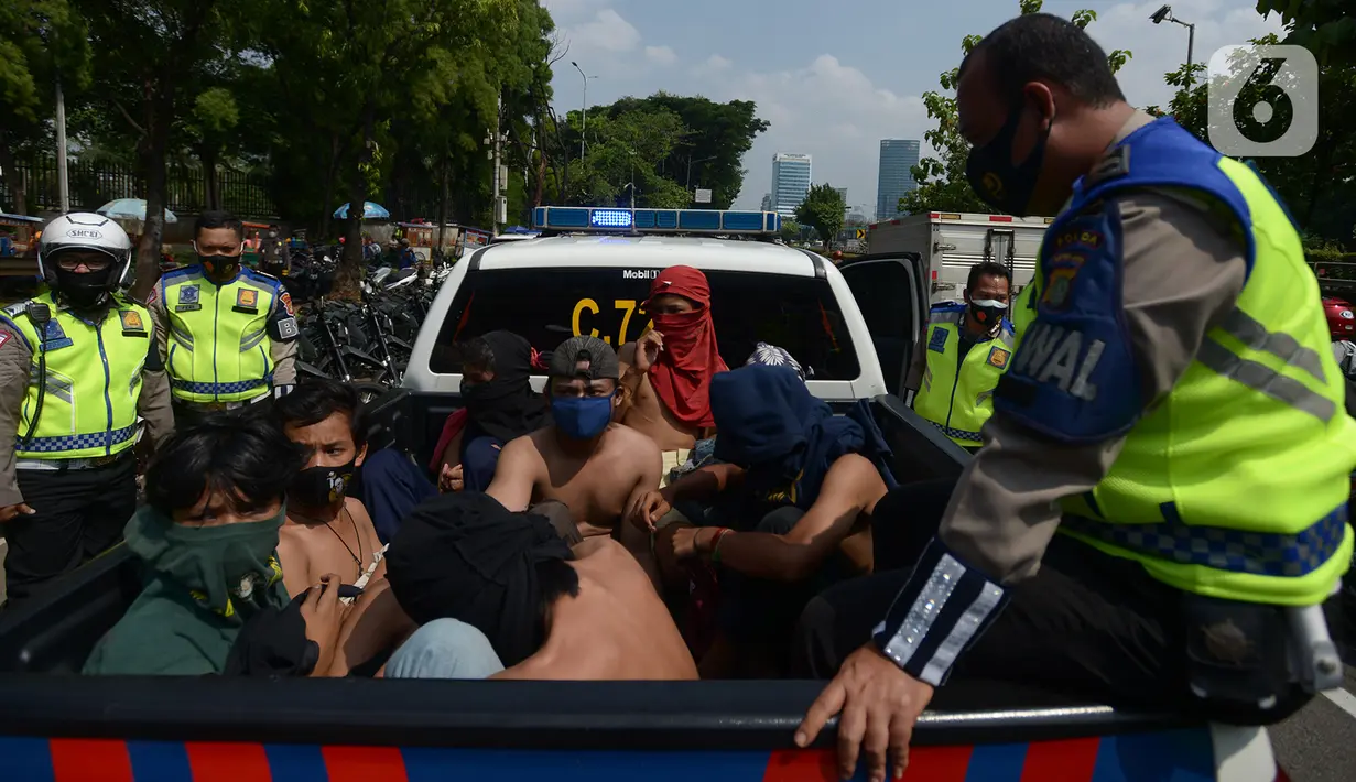 Sejumlah orang dibawa dengan kendaraan polisi setelah diamankan di Kawasan Senayan, Jakarta, Kamis (8/10/2020). Mereka diduga hendak melakukan unjuk rasa di depan gedung DPR. (merdeka.com/Imam Buhori)