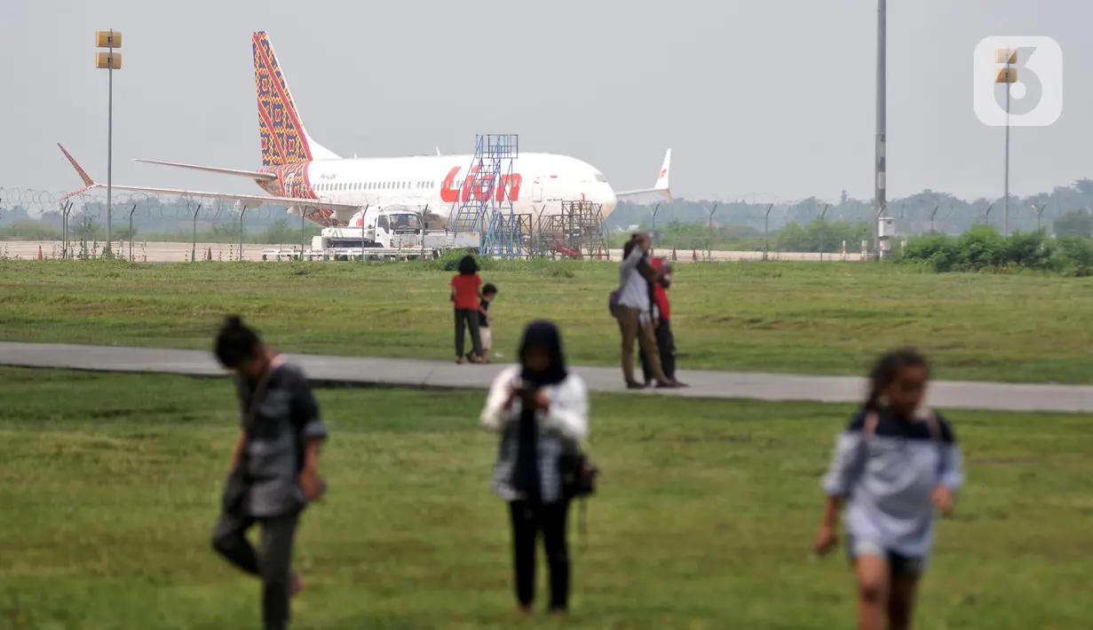 Pengunjung berfoto dengan latar belakang pesawat di Bandara Internasional Jawa Barat (BIJB) Kertajati, Kabupaten Majalengka. Jawa Barat, Minggu (30/1/2022). (merdeka.com/Iqbal S. Nugroho)
