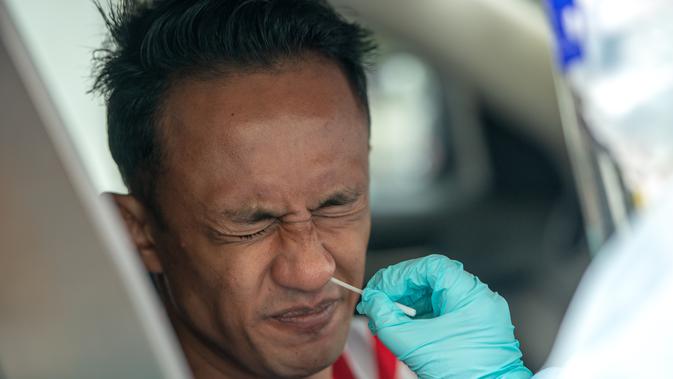 Staf medis mengambil sampel usap (swab) seorang pria di dalam kendaraan untuk tes COVID-19 di Shah Alam, Negara Bagian Selangor, Malaysia (12/12/2020). Malaysia melaporkan 1.937 kasus baru COVID-19, menambah total kasus di negara tersebut menjadi 82.246. (Xinhua/Chong Voon Chung)
