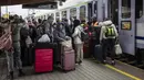 Pengungsi dari Ukraina terlihat di peron menaiki kereta ke Warsawa, di stasiun kereta api di Przemysl, Polandia tenggara, pada 5 April 2022. Lebih dari 4,2 juta pengungsi Ukraina telah meninggalkan negara itu sejak invasi Rusia, kata PBB. (Wojtek RADWANSKI / AFP)