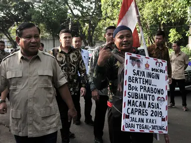 Rahman didampingi Prabowo Subianto berjalan menuju Kantor BPN, Jakarta, Kamis (20/12). Setelah berjalan kaki dari Tegal sejak 2 Juli 201 dengan membawa poster dan bendera Merah Putih, Rahman akhirnya menemui Prabowo. (Merdeka.com/Iqbal S. Nugroho)