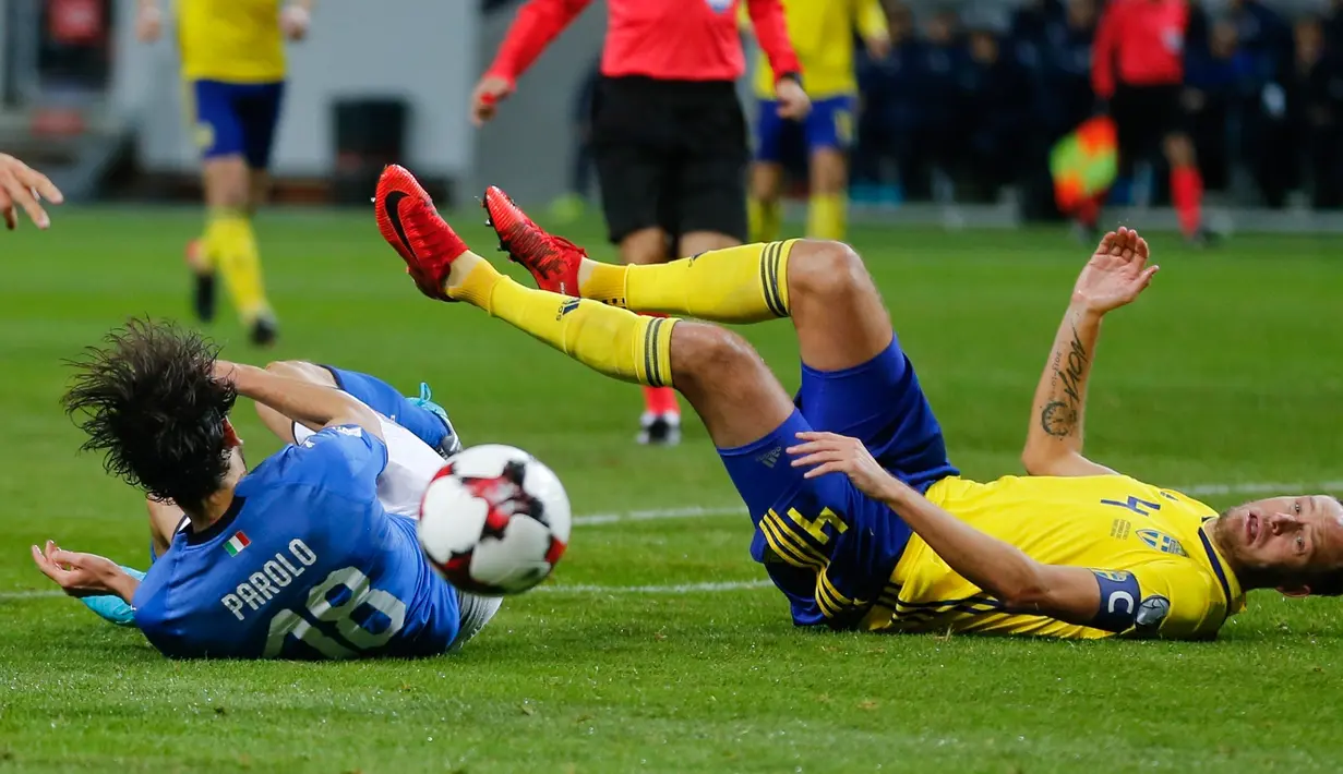 Pemain Italia Marco Parolo (kiri) dan pemain Swedia Andreas Granqvist terjatuh saat berebut bola dalam pertandingan Kualifikasi Piala Dunia 2018 di Stadion Friends Arena, Solna (10/11). (AP Photo/Frank Augstein)