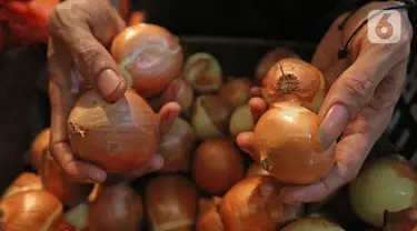 Pedagang memperlihatkan bawang bombay dagangannya di dPasar Induk Kramat Jati, Jakarta, Kamis (12/3/2020). Para pedagang di pasar tradisional, mengeluhkan harga bawang bombay yang melonjak drastis hingga 10 kali lipat dari harga normal. (Liputan6.com/Herman Zakharia)