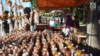 Pedagang menunggu pembeli saat berjualan pelita di Jalan Sam Ratulangi, Kota Gorontalo, Rabu (22/5/2019). Tumbilotohe atau malam pasang lampu yang digelar tiga hari menjelang Idul Fitri merupakan tradisi tua di Gorontalo. (Liputan6.com/Arfandi Ibrahim)