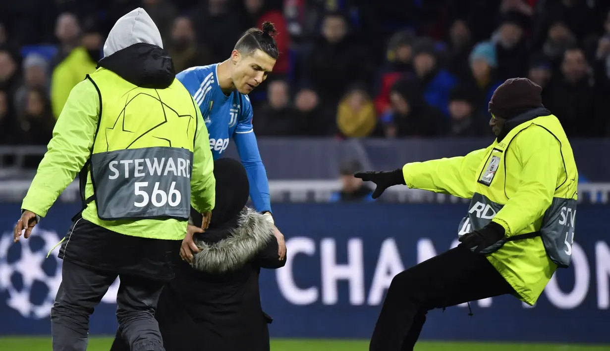 Penyerang Cristiano Ronaldo berbicara dengan seorang penggemar selama pertandingan antara Lyon dan Juventus pada leg pertama babak 16 Liga Champions di Stadion Olimpiade Lyon di Decines, Prancis (26/2/2020). Dalam pertandingan ini Lyon berhasil mengalahkan Juventus 1-0. (AFP/Philippe Desmazes)