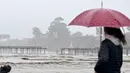 Warga melihat Dermaga Capitola terbelah dua dari Aptos, California pada 9 Januari 2023. Badai besar yang disebut "badai bom" oleh ahli meteorologi telah tiba dan diperkirakan akan menyebabkan banjir yang meluas di seluruh negara bagian. (AFP/Josh Edelson)