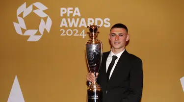 Gelandang Manchester City, Phil Foden berpose dengan trofi penghargaan Pemain Terbaik Pria versi Asosiasi Pemain Sepak Bola Profesional (PFA) di Opera House Manchester, Inggris, Selasa (20/8/2024). (Peter Byrne/PA via AP)