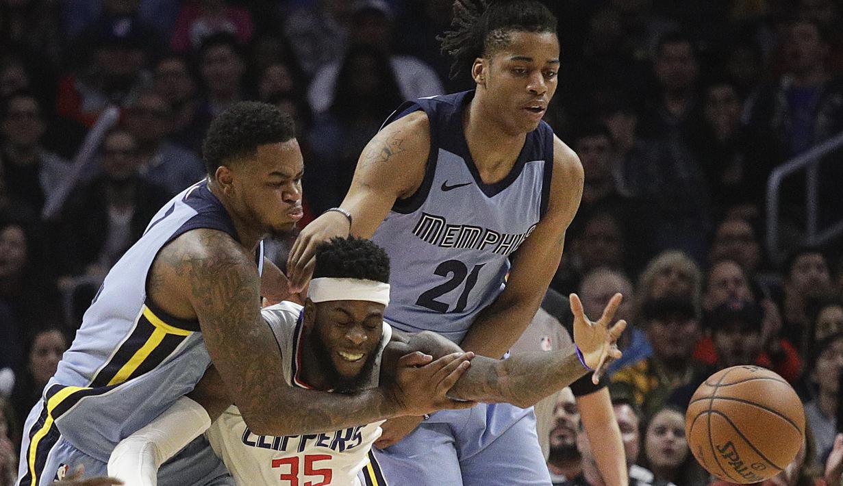 Pemain Los Angeles Clippers, Willie Reed (tengah) berusaha menjangkau bola dari adangan pemain Memphis Grizzlies pada laga NBA basketball game, di Staples Center, Los Angeles, (2/1/2018). Clippers menang 113-105. (AP/Jae C. Hong)
