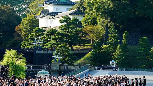 Kaisar Jepang, Naruhito dan Permaisuri Masako menyapa warganya selama parade di Tokyo, Jepang, Minggu (10/11/2019). (AP Photo)