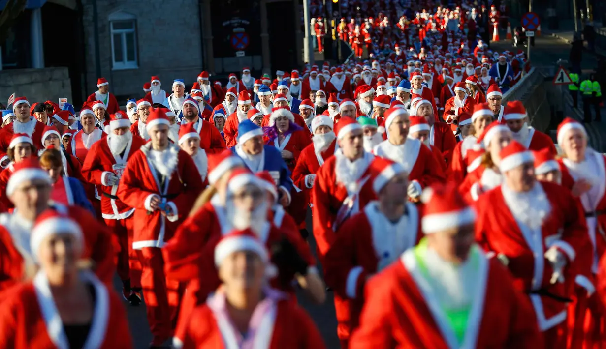 Ribuan peserta mengenakan kostum Santa Claus mengikuti balap lari Santa Dash di Liverpool, Inggris, Minggu (4/12). Lebih dari 8.000 orang diperkirakan mengikuti acara lari 5km Santa Dash yang diselenggarakan tiap tahun tersebut. (Reuters/Phil Noble)